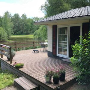 Praktijkvoorbeeld van vlonderstrips bij tuinhuis aan meer, houten ondergronden worden een stuk veiliger met vlonderstrips, uitvoering in kleur bruin